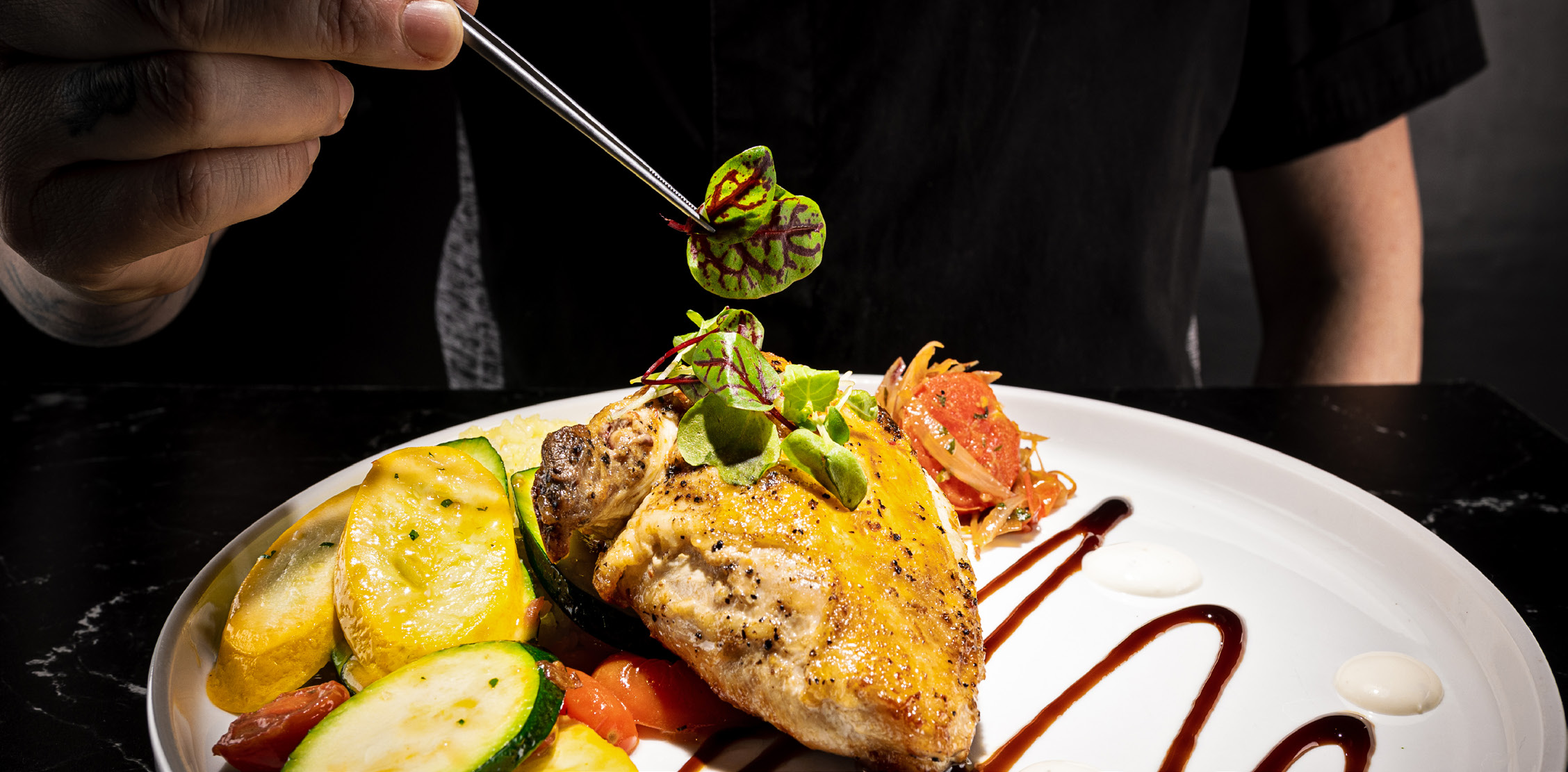 Chef‑plated chicken entrée with seasonal vegetables at 1898 Public House